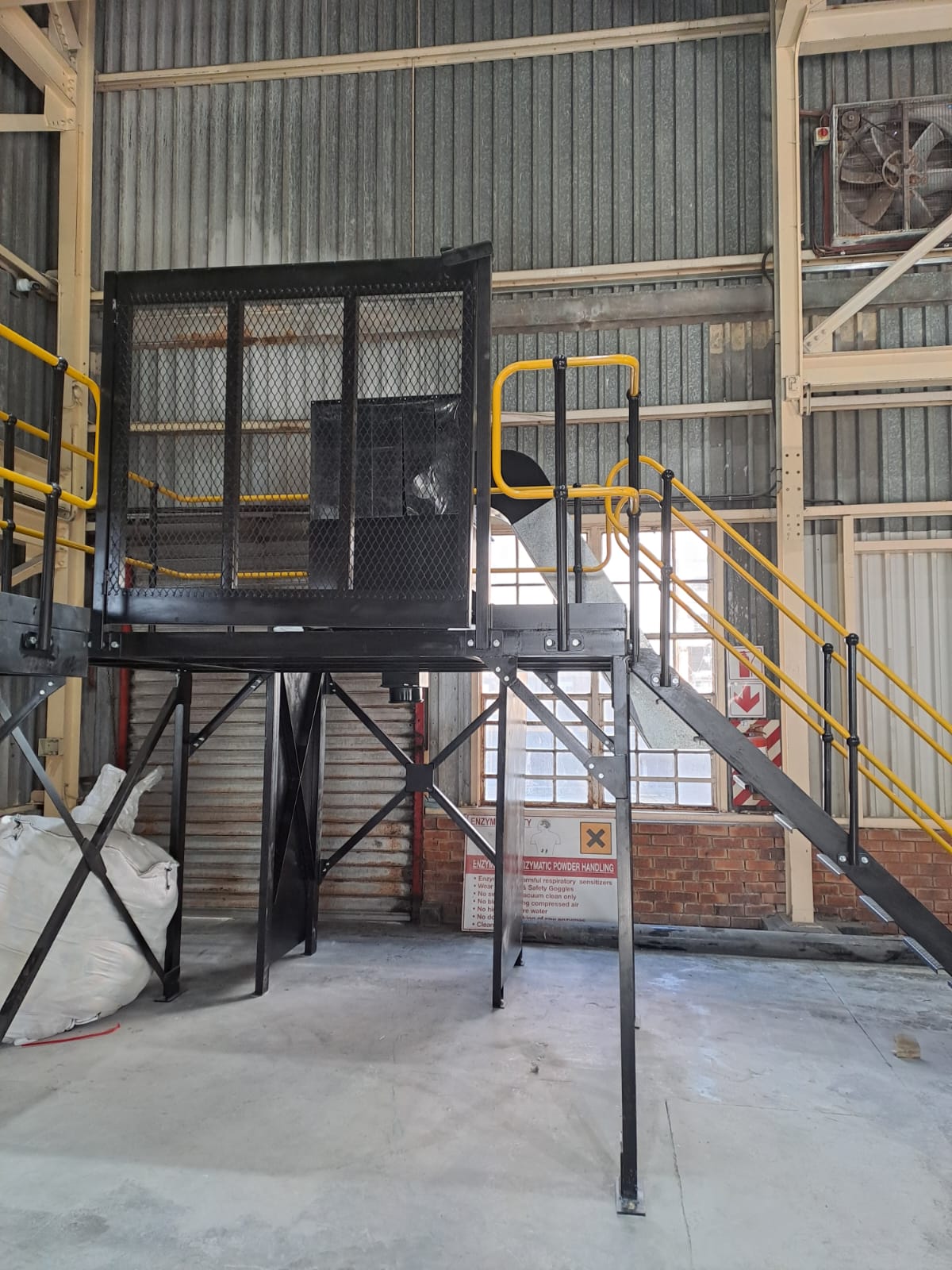 Black steel mezzanine platform with yellow railings